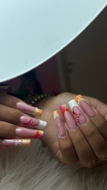 Unghie con decorazioni arancio e dettagli floreali
