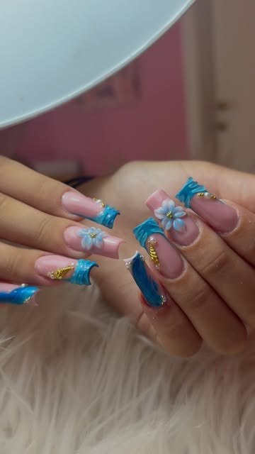 Nail art azzurra con fiori in tre dimensioni
