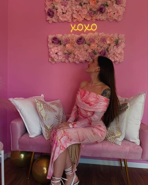 Sara Sartacci nello studio Gossip Nails, davanti alla parete di fiori con l'insegna al neon XOXO